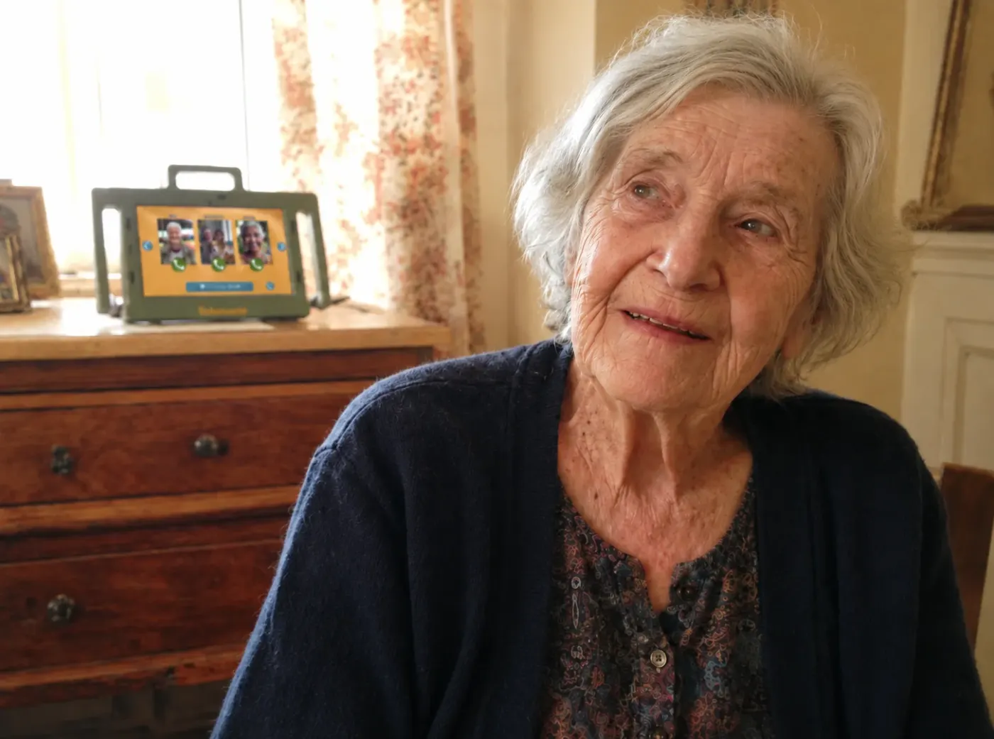 Seniorin sitzt am Frühstückstisch mit Telemarie